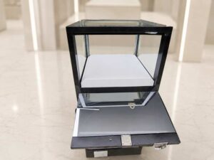 Black glass display cabinet featuring 1 hinged door, 1 drawer, and 1 storage compartment.