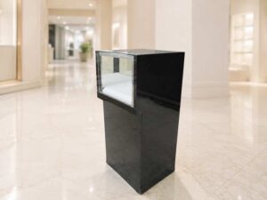 Black glass display cabinet featuring 1 hinged door, 1 drawer, and 1 storage compartment.