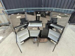 Black glass display counter featuring 3 hinged doors, 3 drawers, and 3 storage compartments.