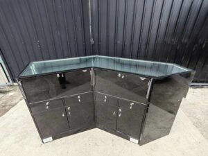 Black glass display counter featuring 2 doors, 4 drawers, and 2 storage compartments.