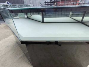 Black glass display counter featuring 2 doors, 4 drawers, and 2 storage compartments.