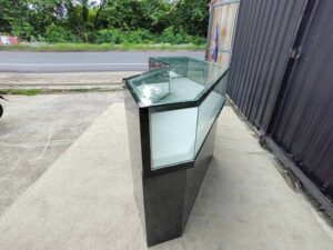Black glass display counter featuring 2 doors, 4 drawers, and 2 storage compartments.
