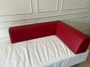 White daybed sofa with red trim, modern style.