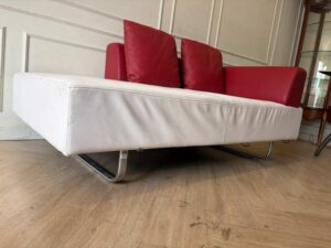 White daybed sofa with red trim, modern style.
