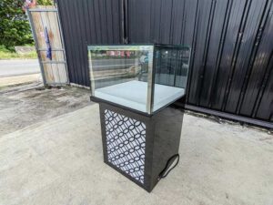 Tall glass display cabinet with one storage compartment; no drawers.