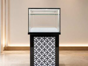 Tall glass display cabinet with one storage compartment; no drawers.