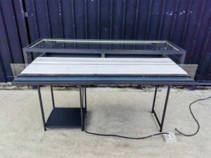 Glass display case, jewelry case, with iron legs and lights.