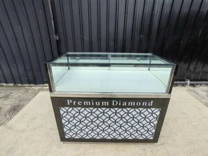 Black glass display cabinet featuring one hinged door, two drawers, and one sliding-door storage compartment.