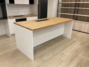 White built-in unit with wooden countertop, overhead cabinets, and refrigerator alcove (1)
