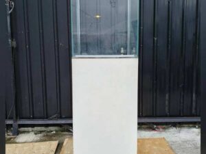 Tall white glass display cabinet with one door and two storage compartments.