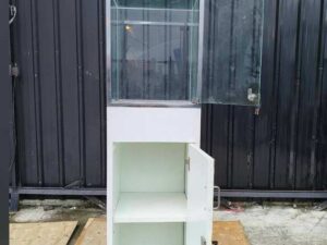 Tall white glass display cabinet with one door and two storage compartments.